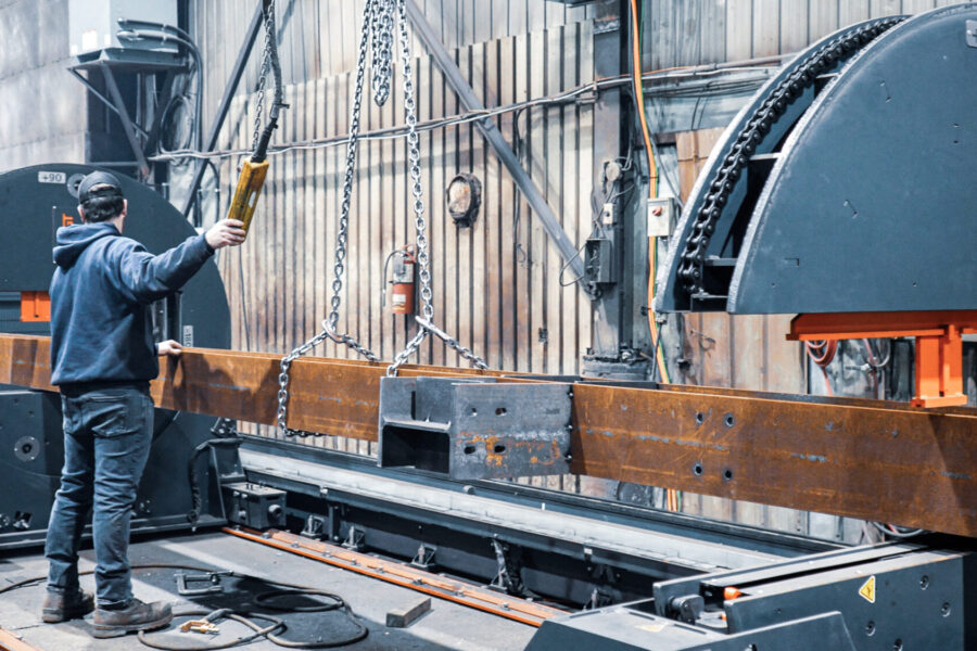 Operator loading steel part in BeamMaster rotators.